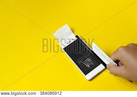 Hand Holding Credit Card And Using Smartfone As Virtual Payment Terminal. Online Shopping. Online Pa