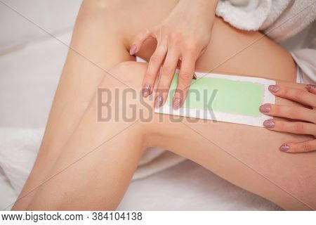 Beautician Waxing A Womans Leg Applying Wax Strip