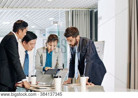 Serious Multi-ethnic Business Team Gathered At Office Table To Discuss Latest News On Global Financi