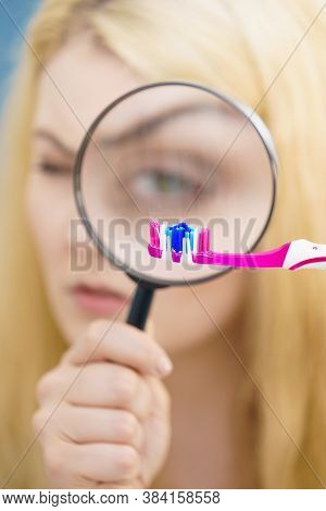 Beautiful Perfectionist Young Woman Checking Her Tooth Brush Through Manifying Loupe Glass. Hygiene,