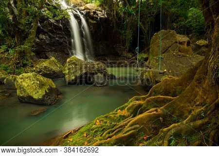 Tropical Landscape. Beautiful Hidden Waterfall In Rainforest. Tree With A Swing. Adventure Concept. 