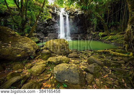 Tropical Landscape. Beautiful Hidden Waterfall In Rainforest. Foreground With Big Stones. Adventure 