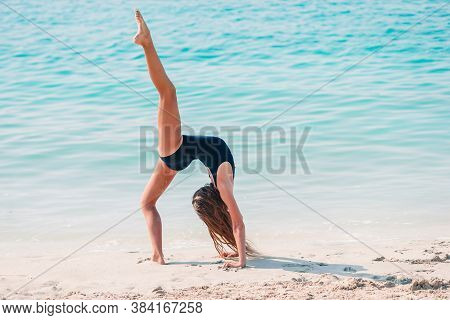 Adorable Active Little Girl At Beach During Summer Vacation