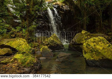 Tropical Landscape. Beautiful Hidden Waterfall In Rainforest. Foreground With Big Stones. Adventure 