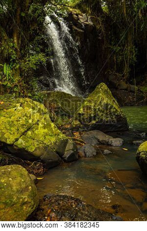 Tropical Landscape. Beautiful Hidden Waterfall In Rainforest. Foreground With Big Stones. Adventure 