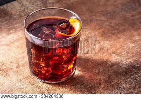 Boulevardier Cocktail And Orange Zest On Rusty Background. Copy Space