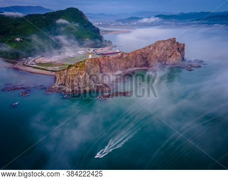 View From Above. Beautiful Cape Briner With Rudny Lighthouse On The Background Of Morning Fog