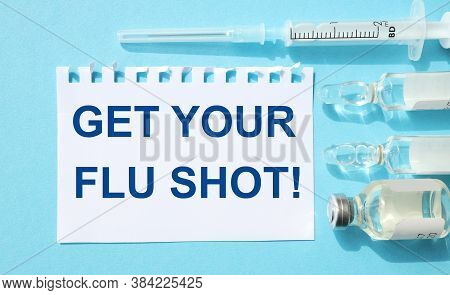 Get Your Flu Shot. Text On White Paper On Blue Background Fozle Ampoules And Syringe, Close-up