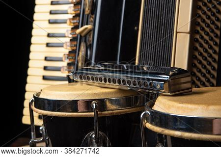 Old Accordion, Harmonica And Bong On Rustic Wooden Surface With Black Background And Low Key Lightin