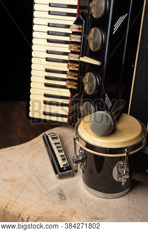 Old Accordion, Harmonica, Bong And Microphone On A Rustic Wooden Surface With Black Background And L