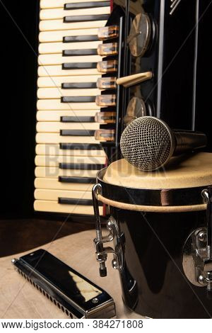 Old Accordion, Harmonica, Bong And Microphone On A Rustic Wooden Surface With Black Background And L
