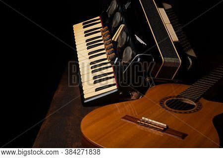 Old Accordion And A Beautiful Guitar Composing A Scene On A Rustic Wooden Surface With Black Backgro