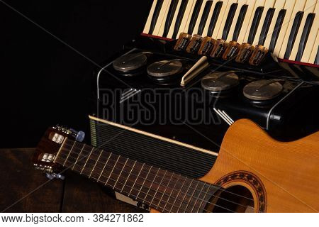 Old Accordion And A Beautiful Guitar Composing A Scene On A Rustic Wooden Surface With Black Backgro