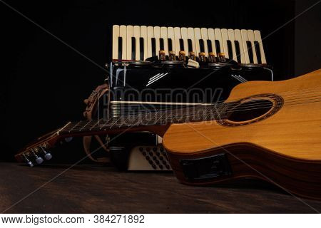 Old Accordion And A Beautiful Guitar Composing A Scene On A Rustic Wooden Surface With Black Backgro