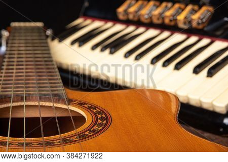 Old Accordion And A Beautiful Guitar Composing A Scene On A Rustic Wooden Surface With Black Backgro