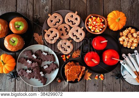Rustic Halloween Treat Table Scene Over A Dark Wood Background. Top View. Variety Of Candied Apples,