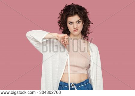 Dislike. Portrait Of Dissatisfied Beautiful Brunette Young Woman With Curly Hairstyle In Casual Styl