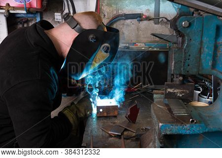 Electric Welding Process. Worker In Welding Mask. Bright White And Blue.