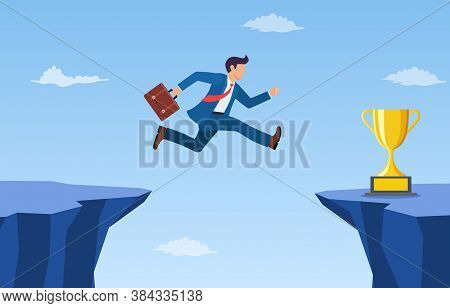 Businessman Jump Through The Gap To Get Golden Trophy. An Employee With A Running Jump From One Clif