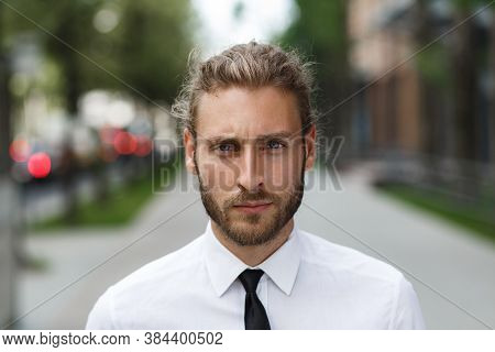 Portrait Of A Handsome Curly-haired Man, In A Business Style. The Astute Look Of An Attractive Busin