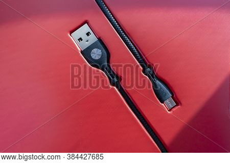 Black Micro-usb To Usb Cable Connector On A Red Background.