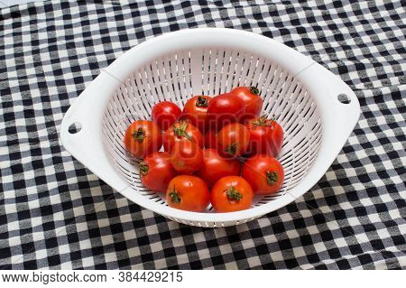 juicy red tomatoes in table cloth . caro background