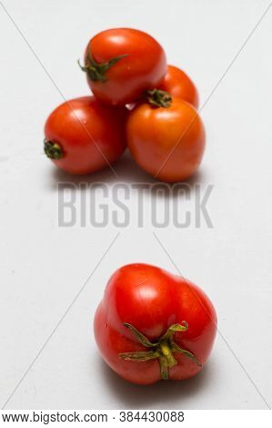 juicy red tomatoes in table cloth . caro background