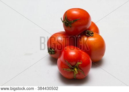 juicy red tomatoes in table cloth . caro background
