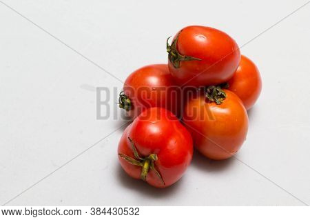 juicy red tomatoes in table cloth . caro background