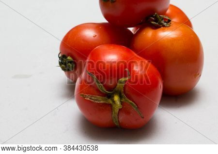 juicy red tomatoes in table cloth . caro background