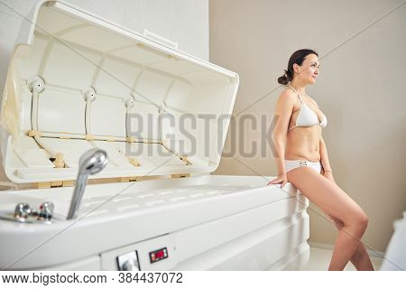 Smiling Lady Sitting On The Edge Of Spa Capsule