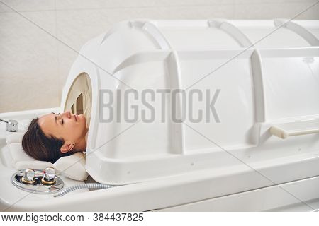 Pleased Lady In Spa Capsule Relaxing With Closed Eyes
