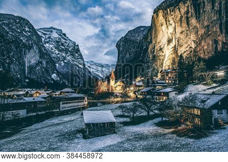 amazing touristic alpine village at night in winter with famous church and Staubbach waterfall  Lauterbrunnen  Switzerland  Europe