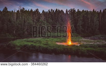 Landscape Of Pine Forest And River. Sunset Sky. Huge Fire. Midsummer Ligo Celebration. Latvian Tradi
