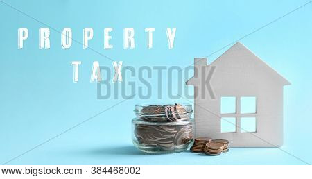 Text Property Tax Near Jar Full Of Coins And House Model On Light Blue Background. Banner Design