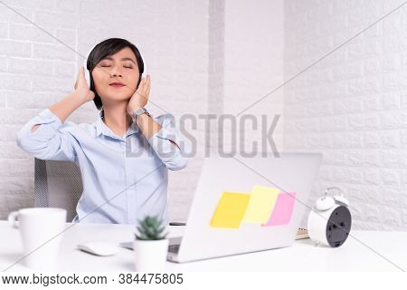 Happy Woman With Headphones Listening Music At Office