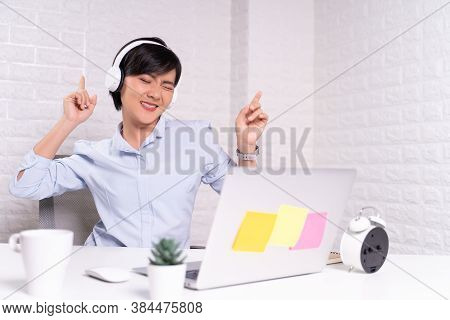 Happy Woman With Headphones Listening Music At Office