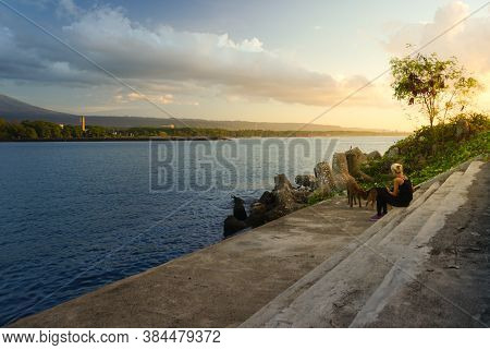 Banyuwangi, Indonesia - July 27, 2020  : A Woman With The Dogs Walking At New Marina Boom Beach Bany