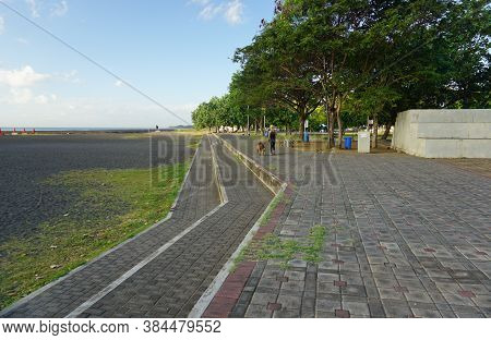 Banyuwangi, Indonesia - July 27, 2020  : A Woman With The Dogs Walking At New Marina Boom Beach Bany