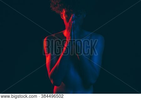 African Man Portrait. Neon Light. Frustrated Black Guy In Blue Red Glow Closing Mouth By Hands Isola
