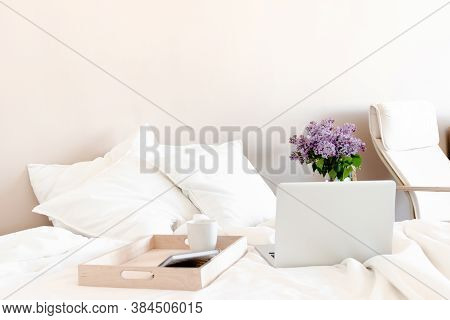 Bright Room With Laptop, Mug And Notepad On A Wooden Stand In Bed.