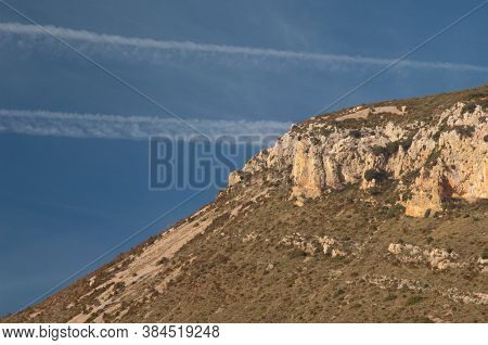 Contrails of airplanes and crag. Natural Park of the Mountains and Canyons of Guara. Huesca. Aragon. Spain.