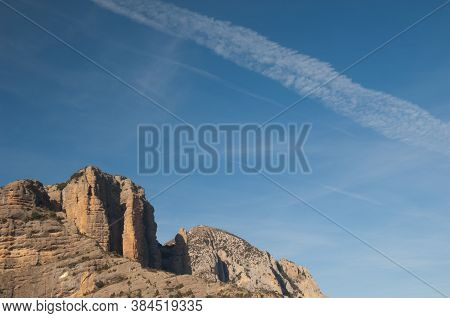 Crags of Mallos de Laza and contrails of airplanes. Natural Park of the Mountains and Canyons of Guara. Huesca. Aragon. Spain.