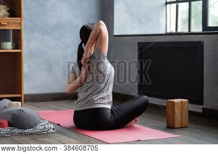 Sportive Woman Making Yoga Asana Gomukhasana In Siddhasana
