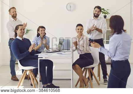 Group Of Smiling Business People Sitting In Office And Discussing New Project Or Startup Together
