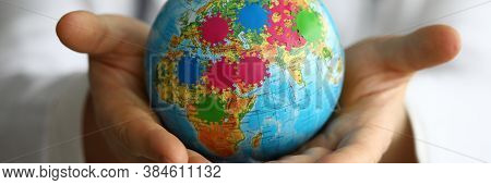 Close-up Of Person Holding Small Globe In Hands. Male In Presentable Suit. Extension Of Microbes And