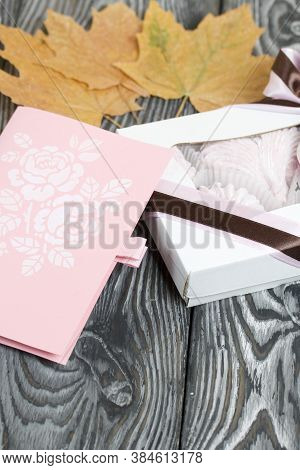 Marshmallow In A Gift Box. Tied With A Ribbon Tied To A Bow. Next To The Greeting Card. Dried Maple