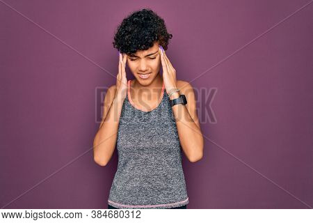 Young beautiful african american afro sportswoman doing exercise wearing sportswear with hand on headache because stress. Suffering migraine.