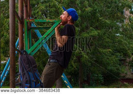 Athlete Doing Pull-up On Horizontal Bar. Male Sportsman Doing Fitness Exercises On Playground Outdoo
