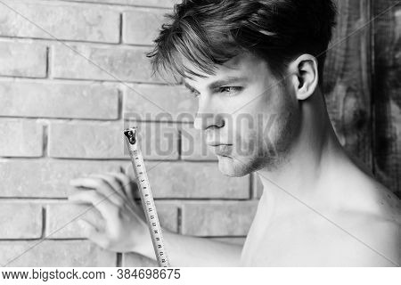 Man With Naked Body Holds Yellow Self Retracting Tape Measure